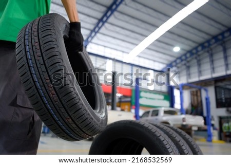 change tire In the process of bringing 4 new tires that are in stock in order to change the wheels of the car at a service center or an auto repair shop for the automobile industry