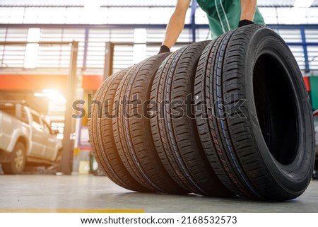 Male car mechanic change tire In the process of bringing 4 new tires in the tire shop to replace the wheels of a motorcycle at a service center or auto repair shop for the automobile industry