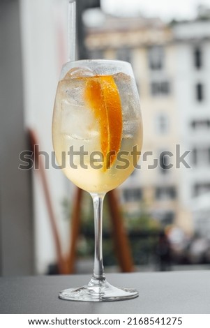 A glass of Spritz cocktail served on the terrace of urban bar. Popular Italian wine based beverage and summer aperitif refreshing drink.