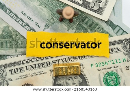 conservator.The word is written on a slip of paper,on colored background. professional terms of finance, business words, economic phrases. concept of economy.
