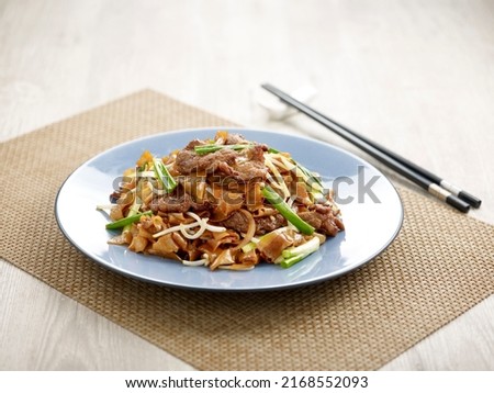 Stir-fried Hor Fun with Sliced Beef with chopsticks served in a dish isolated on mat side view on grey background Royalty-Free Stock Photo #2168552093