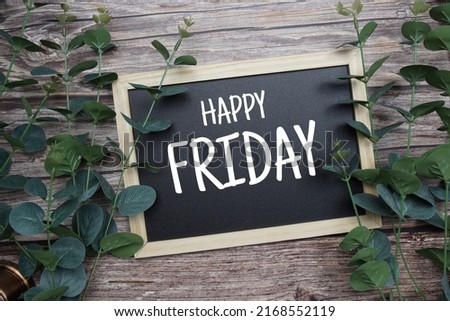 Happy Friday typography text written on wooden blackboard with green eucalyptus decoration on wooden background