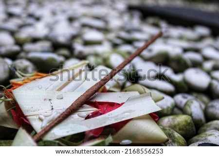 Balinese Hindu canang and dupa on white pebbles