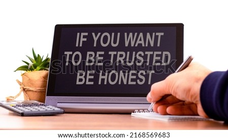 Be trusted and honest symbol. Concept words If you want to be trusted be honest on the black tablet. Businessman hand with pen. Business and be trusted and honest concept. Copy space.