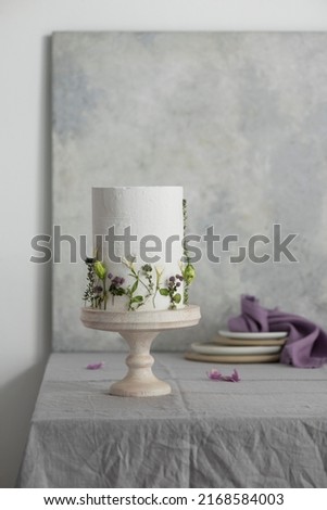 White wedding cake with lillac and green flowers, selective focus image