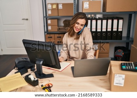 Young woman ecommerce business worker talking on the smartphone working at office