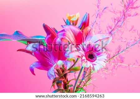 Design for picture, wallpaper. Beautiful bouquet of flowers, abstract floral composition in glass vase over pink, magenta background in neon light. Concept of floristry, decorations, creativity, decor