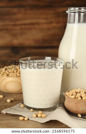 Fresh soy milk and grains on wooden table