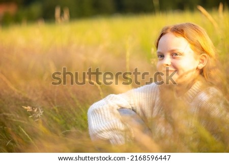 Fall fashion concept. Beautiful young woman in a cozy knitted sweater. Outdoor photo of funny hipster girl wearing trendy casual outfit. Warm light sunset. High quality photo