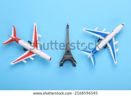 Travel concept. Toy planes with eiffel tower figurine on a blue background