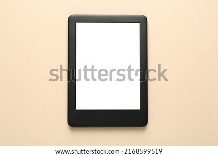 Modern e-book reader with blank screen on beige background, top view