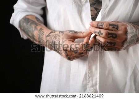 Young man with tattoos on body against black background, closeup Royalty-Free Stock Photo #2168621409