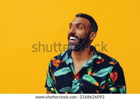 happy smiling african american man wearing Hawaiian shirt looking away at copy space mid adult studio shot
