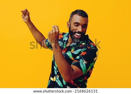 close up handsome bearded mid adult african american man smiling and dancing wearing Hawaiian shorts and shirt on vacation studio shot Royalty-Free Stock Photo #2168626131