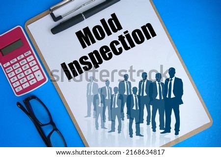 Text written Mold Inspection at white paper on clipboard with glasses and calculator on blue background 