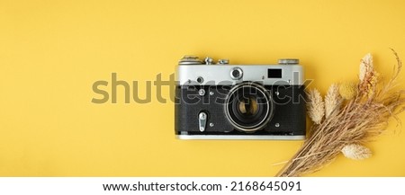 Old retro camera on the yellow background. Stylish background for a photo enthusiast. Flat lay