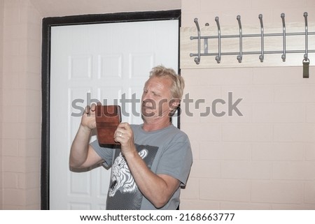 A man with a phone in the hallway photographs the interior of a small apartment. Buying and selling real estate.
