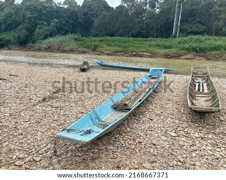 Wooden boat on the river stones