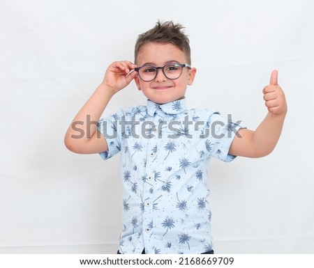 A child wearing glasses and doing a well done sign on a white background
