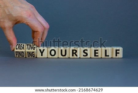 Finding or creating yourself symbol. Businessman turns wooden cubes and changes words Finding yourself to Creating yourself. Beautiful grey background, copy space. Business creating yourself concept.