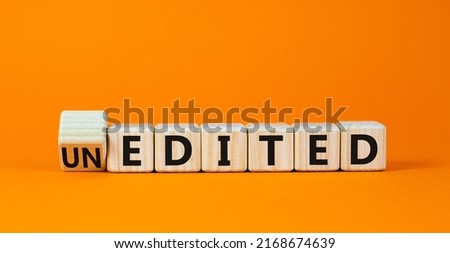 Edited or unedited symbol. Turned wooden cubes and changed the concept word Unedited to Edited. Beautiful orange table orange background. Business and edited or unedited concept. Copy space.
