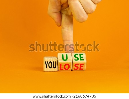 You use or lose it symbol. Concept words You use and You lose on wooden cubes. Businessman hand. Beautiful orange table orange background. Business and you use or lose it concept. Copy space. Royalty-Free Stock Photo #2168674705
