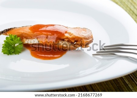 Marinated herring fish with tomato sauce on plate with fork