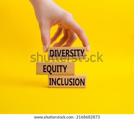 Diversity Equity Inclusion symbol. Concept words Diversity Equity Inclusion on wooden blocks. Beautiful yellow background. Bisinessman hand. Business and Diversity Equity Inclusion concept. Copy space