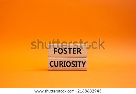 Foster curiosity symbol. Concept word Foster curiosity on wooden blocks. Beautiful orange background. Business and Foster curiosity concept. Copy space. Conceptual image Royalty-Free Stock Photo #2168682943