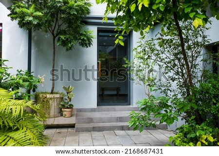 Modern door in summer garden. Royalty-Free Stock Photo #2168687431