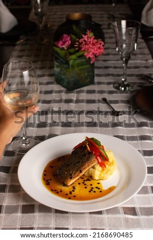 Grilled fish loin on mashed potatoes and passion fruit sauce