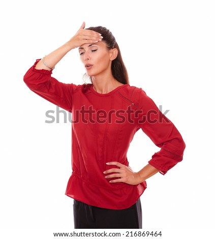 Portrait of alone young woman with headache and closed eyes standing on isolated studio