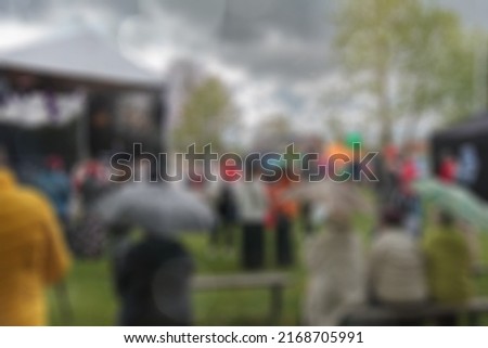 Blur background of people in park fair, summer festival, toning. Abstract blur image of garden festival day with bokeh for background use, vintage tone