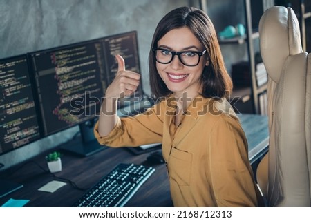 Portrait of beautiful cheerful girl web designer developing web startup showing thumbup done at workplace workstation indoors Royalty-Free Stock Photo #2168712313