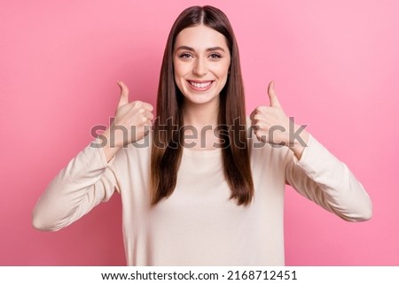 Portrait of attractive cheerful brown haired girl showing two thumbup ad yes agree isolated over pink pastel color background