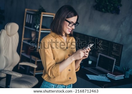 Portrait of attractive cheerful focused girl expert using device gadget app editing post at workplace workstation indoors