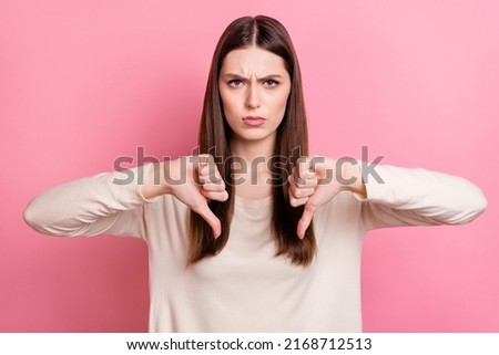 Portrait of attractive grumpy brown haired girl showing thumb down no against isolated over pink pastel color background Royalty-Free Stock Photo #2168712513