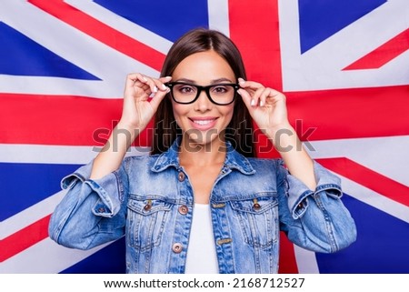 Photo of positive charming lady hands touch eyeglasses toothy smile isolated on british national flag