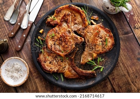 Grilled or pan fried pork chops on the bone with garlic and rosemary Royalty-Free Stock Photo #2168714617