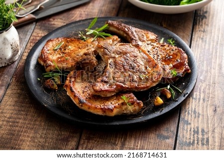 Grilled or pan fried pork chops on the bone with garlic and rosemary Royalty-Free Stock Photo #2168714631