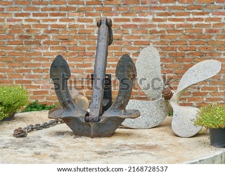 An old rusty anchor and propeller.          