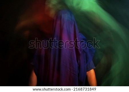 blurry faceless portrait in the dark, slow shutter speed photography