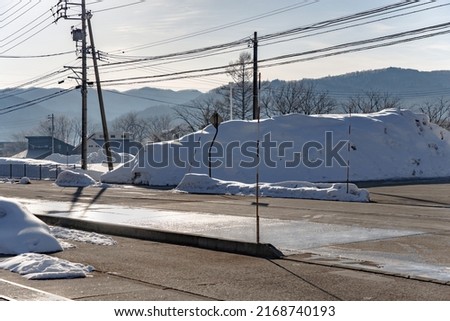 HAKUBA, JAPAN - FEBRUARY 12th 2022 - pavement and road in a village where the snow was cleared