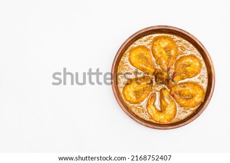 Bengali Dish or Food - Delicious authentic Bengali Prawn Malai Curry also known as chingri malai curry served on a wooden bowl. Traditional Goan Prawns or Shrimp curry. top view white background. Royalty-Free Stock Photo #2168752407