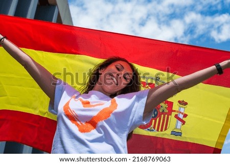Young woman smiling with the Spanish flag. Happy young adult waving a flag.