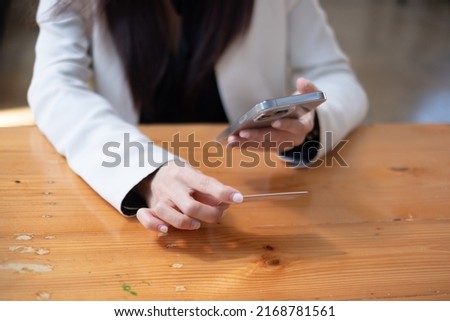 Online payment, woman's hands holding a credit card and using a smartphone for online shopping