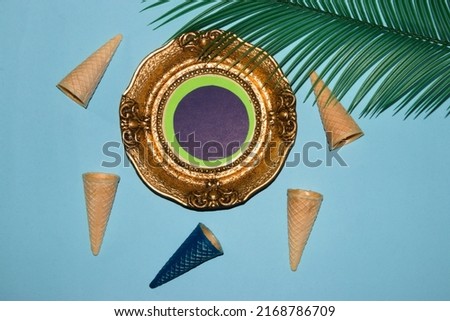 old retro frame as copy space, around it pastel blue background with ice cream zone and palm leaf, creative summer design