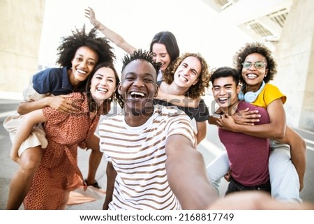 Multiracial friends taking selfie group picture with smart mobile phone outside on city street - Happy young people smiling together looking at camera - Youth lifestyle concept with teens hanging out Royalty-Free Stock Photo #2168817749
