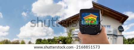 Close-up Of Person Detecting Heat Loss Outside House Using Infrared Thermal Camera Royalty-Free Stock Photo #2168851573