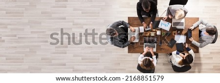 Overhead View Of Diverse Businesspeople Working At Workplace In Office